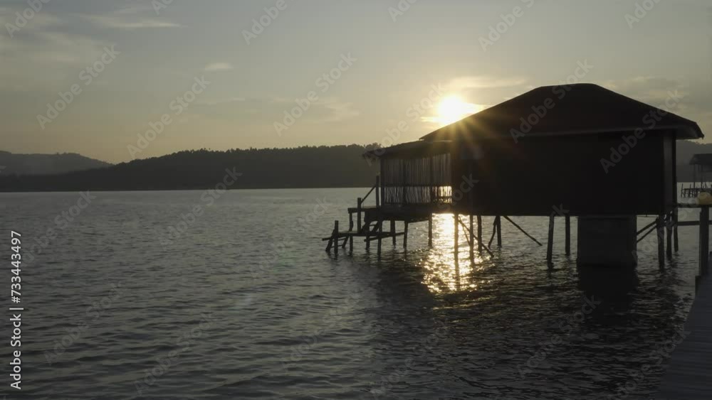 Water Villa at Piugus Island, Anambas Islands, Indonesia while sunset with sparkling sunlight reflection on the sea water surface. Concept for tropical island trip. Water Villa at Piugus Island, Anambas Islands, Indonesia while sunset with sparkling sunlight reflection on the sea water surface. Concept for tropical island trip.