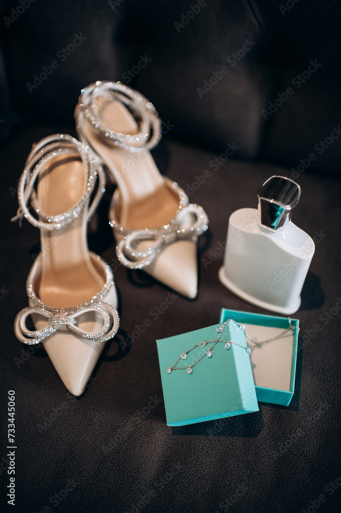 A modern composition of elegant wedding accessories for an attractive bride. Wedding rings, wedding bouquets, bottle of perfume, elegant fashionable shoes, jewelry. Preparation of the bride A modern composition of elegant wedding accessories for an attractive bride. Wedding rings, wedding bouquets, bottle of perfume, elegant fashionable shoes, jewelry. Preparation of the bride