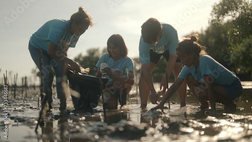 Group of volunteers cleaning on the beach photo