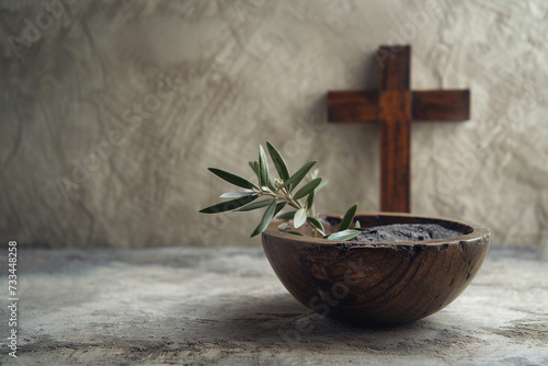 Ash Wednesday, faith, liturgy, religious ceremony background. Wooden cross, ceremonial dish with ash and olive branch on gray background © vejaa