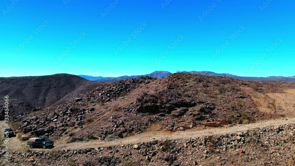 Aerial: Drone Shot Of Off-Road Vehicles Moving In High Desert Region Against Clear Sky On Sunny Day - Landers, California Aerial: Drone Shot Of Off-Road Vehicles Moving In High Desert Region Against Clear Sky On Sunny Day - Landers, California