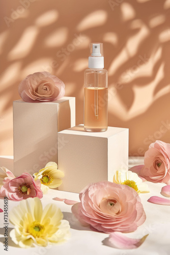 A bottle of perfume surrounded by flowers on a table.