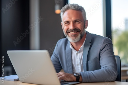 Smiling mature adult business man sitting at work