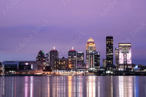 Beautiful sunset night view of Louisville Kentucky Skyline with river, bridge and lit buildings