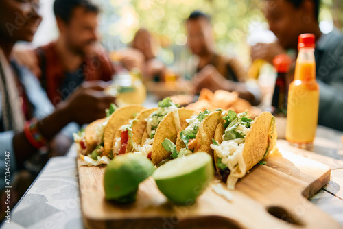 Cuadro en lienzo Close up of tacos with group of friends in background.