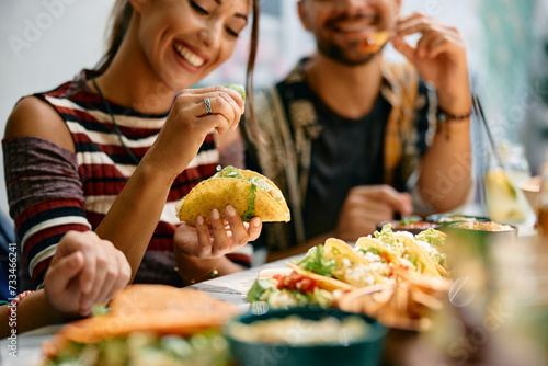 Cuadro en lienzo Close up of woman squeezing lime in her tacos while eating in Mexican restaurant