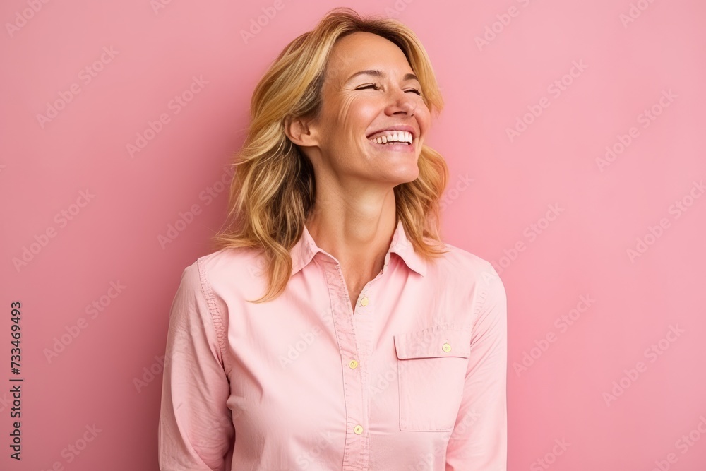 Portrait of a happy young woman laughing and looking up over pink background Portrait of a happy young woman laughing and looking up over pink background