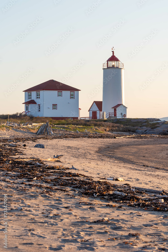 At the sunset the lighthouse of L’Isle-Verte with the beach in foreground (Notre-Dame-des-Sept-Douleurs, L’Isle-Verte, Quebec, Canada)