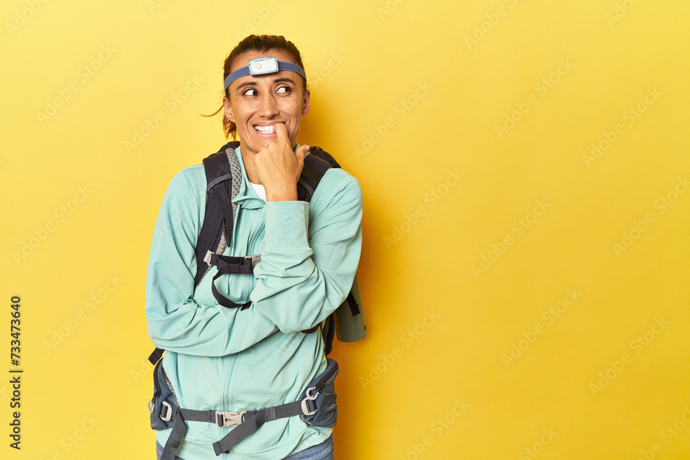 Mountain gear and frontal light on yellow relaxed thinking about something looking at a copy space. Mountain gear and frontal light on yellow relaxed thinking about something looking at a copy space.