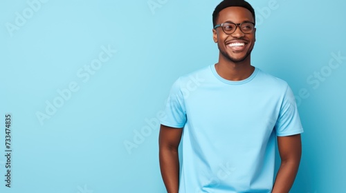 Attractive african american man wearing blue tshirt and glasses. Isolated on blue background.