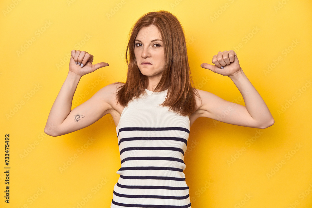 Redhead in a tank top, casual studio shot feels proud and self confident, example to follow. Redhead in a tank top, casual studio shot feels proud and self confident, example to follow.