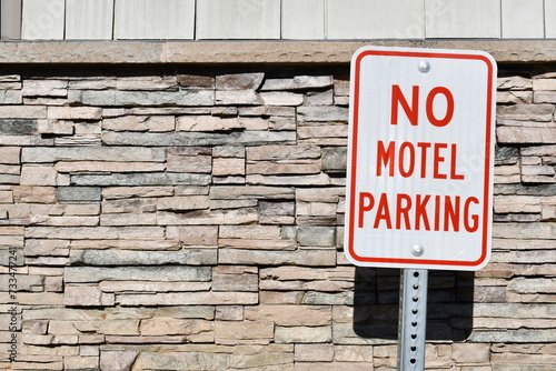 No motel parking sign. Stone veneer siding in the background.