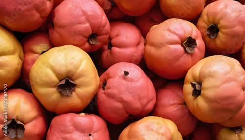 A close-up view of a group of ripe, vivid Quince with a deep, textured detail. © Antonio Giordano