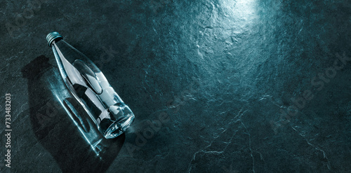Foto Bottle of water on blue stone background