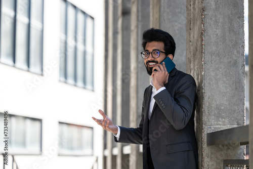 Young businessman having a phone conversation and looking excited