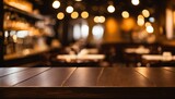 Restaurant setting: Empty wood table with soft golden bokeh lights in a darkened environment