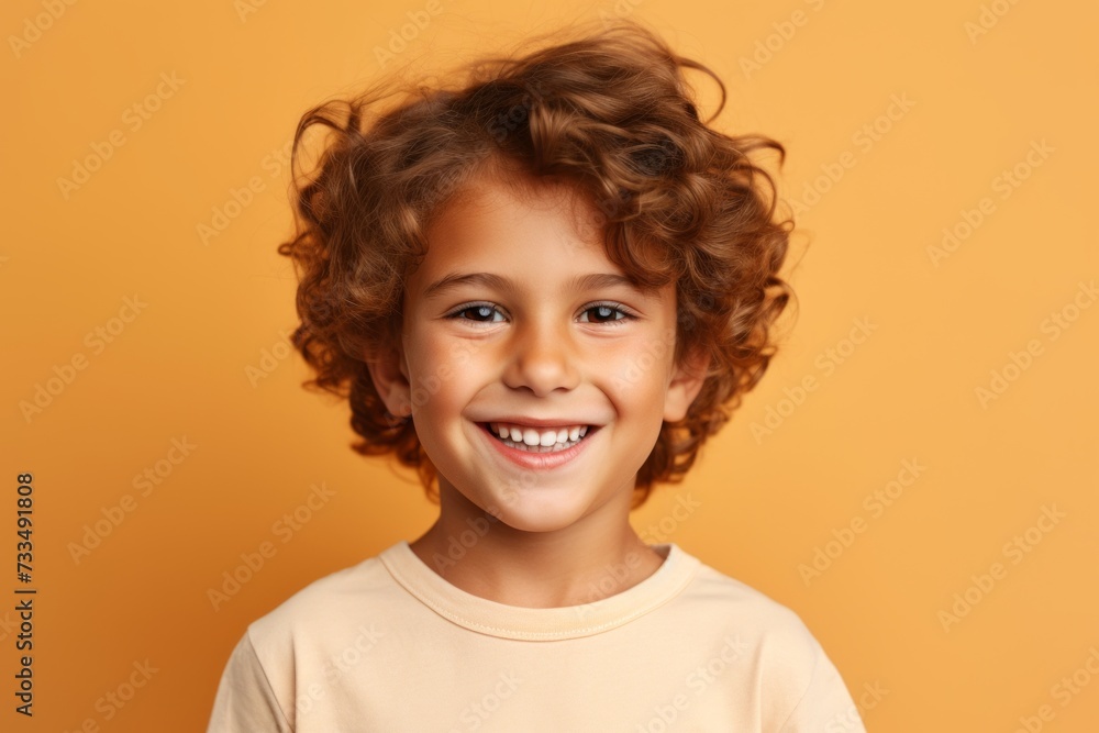 Portrait of smiling little boy with curly hair over yellow background. Portrait of smiling little boy with curly hair over yellow background.