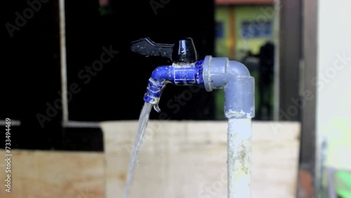 water is flowing through a faucet near the wall