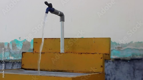 water is flowing through a faucet near the wall