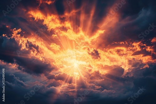 Sun beams breaking through dark clouds at sunset, symbolizing hope and grace. © darshika