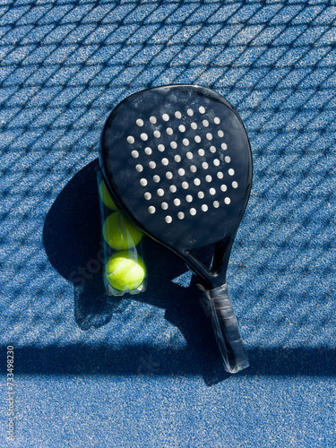 Pala de pádel con una pelota para jugar el deporte de mayor crecimiento en los últimos años a nivel mundial. Cancha de pádel en verano, el momento perfecto para practicar esta disciplina deportiva.
