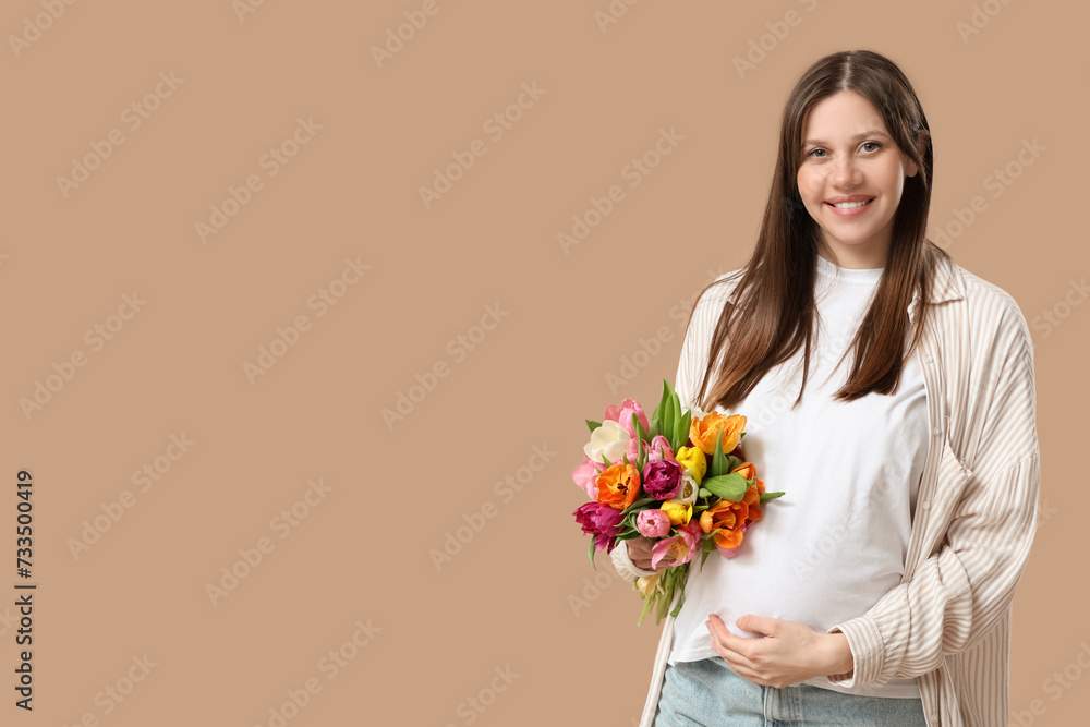 Happy young pregnant woman with bouquet of tulips on brown background. International Women's Day Happy young pregnant woman with bouquet of tulips on brown background. International Women's Day