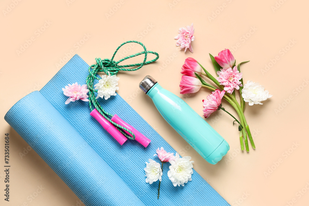 Composition with sports equipment, bottle of water and spring flowers on color background. International Women's Day