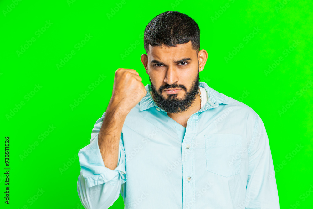 Aggressive angry Indian young man trying to fight at camera, shaking fist, boxing with expression, punishment, threaten, bullying, abuse, mad fury. Arabian guy isolated on green chroma key background Aggressive angry Indian young man trying to fight at camera, shaking fist, boxing with expression, punishment, threaten, bullying, abuse, mad fury. Arabian guy isolated on green chroma key background