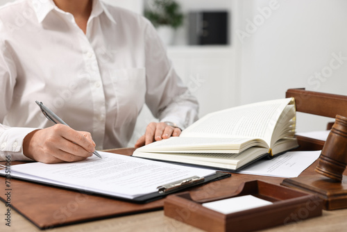 Lawyer working with documents at wooden table in office, closeup