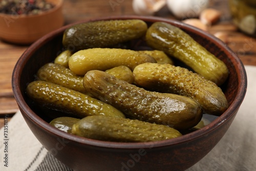 Tasty pickled cucumbers in bowl on table, closeup