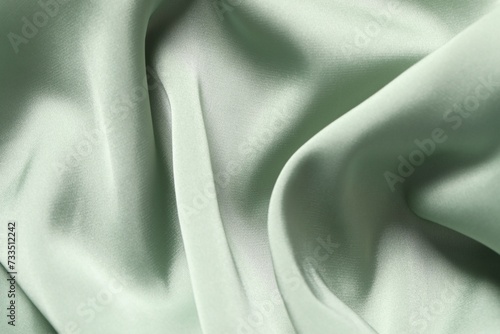 Texture of light green crumpled silk fabric as background, top view