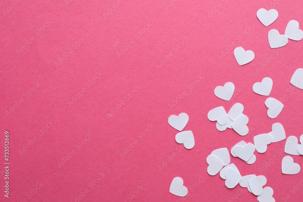White paper hearts on pink background, flat lay. Space for text