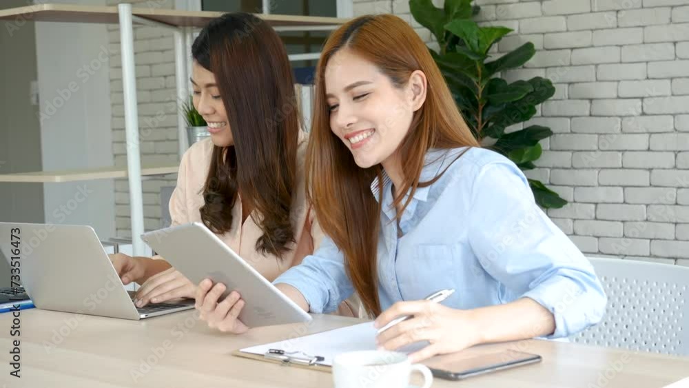 Two start up business partners enjoy good news from smartphone. Teamwork collaboration teamwork concept. Asian woman Business people working Together at home office. Success confident women teamwork Two start up business partners enjoy good news from smartphone. Teamwork collaboration teamwork concept. Asian woman Business people working Together at home office. Success confident women teamwork
