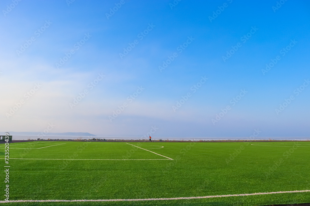 soccer field with sky and white clouds