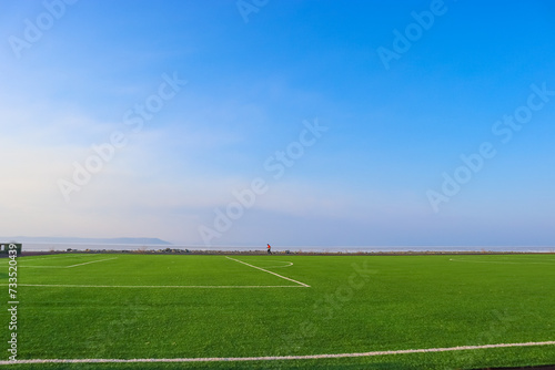 soccer field with sky and white clouds