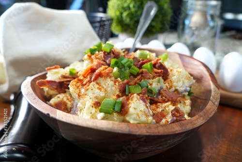 creamy homemade potato salad in a bowl topped with bacon and chives