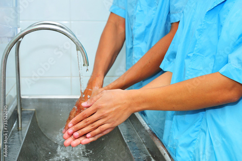 Male and female washing hands in factory sanitation 