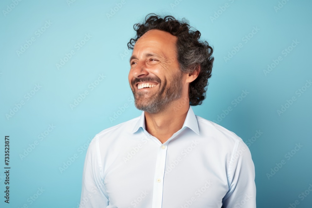 Portrait of a happy middle-aged man in a white shirt on a blue background Portrait of a happy middle-aged man in a white shirt on a blue background