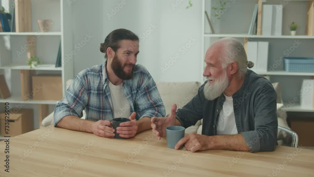 Two friends, a young man and an older man, are sitting at a table, discussing life situations and providing each other with psychological support, friendly communication, intergenerational dialogue Two friends, a young man and an older man, are sitting at a table, discussing life situations and providing each other with psychological support, friendly communication, intergenerational dialogue
