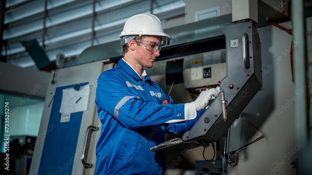 Industry engineer worker wearing safety uniform control operating computer controlled Lathe grinding machine working in industry factory is metal manufacturing industry concept. Industry engineer worker wearing safety uniform control operating computer controlled Lathe grinding machine working in industry factory is metal manufacturing industry concept.