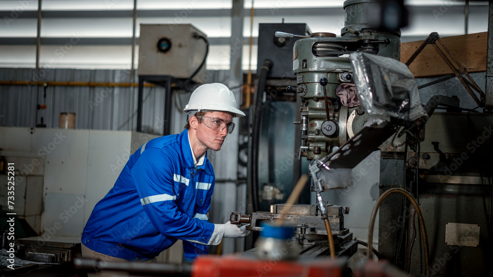 Industry engineer worker wearing safety uniform control operating computer controlled Lathe grinding machine working in industry factory is metal manufacturing industry concept. Industry engineer worker wearing safety uniform control operating computer controlled Lathe grinding machine working in industry factory is metal manufacturing industry concept.