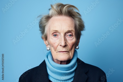Portrait of senior woman with wrinkles on her face against blue background