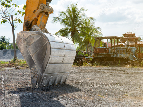 The head of the loader is planted on the ground ready to work outdoors.