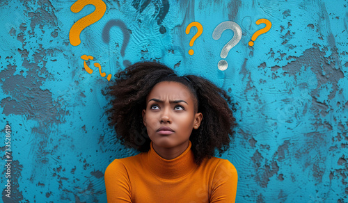 Young African American girl expressing doubt on her face  with question symbols around her head. Image for advertising  web or commercial.