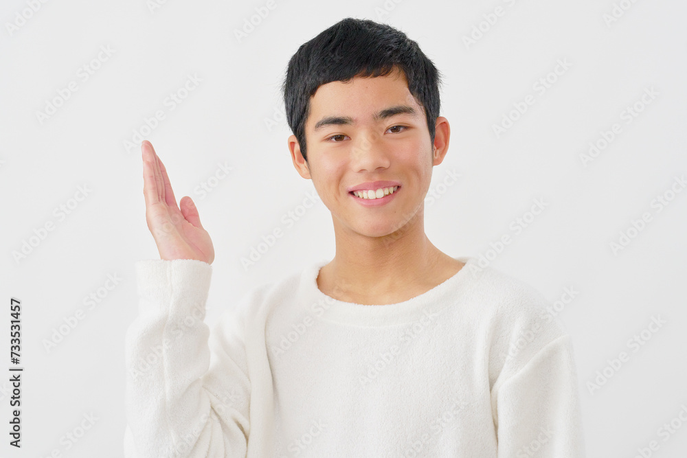 手のひらで左側を指す男の子　白背景