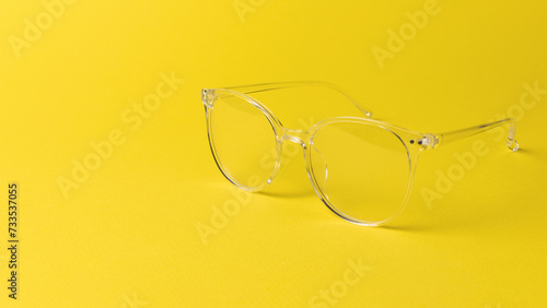 Stylish transparent glasses on a yellow background.