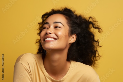 happy african american woman with long curly hair on yellow background © Iigo