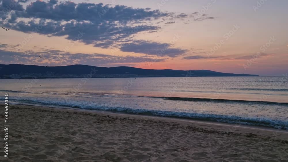 Dawn at the sea with foamy waves on the sand and colorful sky at the horizon. Sunny Beach coastline in Bulgaria. Summer and travel background Dawn at the sea with foamy waves on the sand and colorful sky at the horizon. Sunny Beach coastline in Bulgaria. Summer and travel background