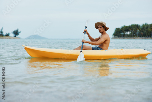 Summer Fun Kayaking on a Tropical Beach  Active Asian Man Enjoying Water Sports and Leisure Vacation