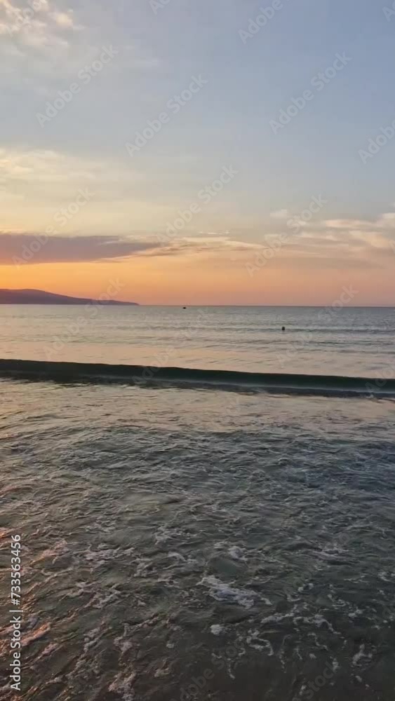 Vibrant sunrise at the Bulgarian coastline of Black Sea. Sunny beach resort, dawn scene with the sun rising up the hills on the horizon and foamy waves washing the sand shore Vibrant sunrise at the Bulgarian coastline of Black Sea. Sunny beach resort, dawn scene with the sun rising up the hills on the horizon and foamy waves washing the sand shore